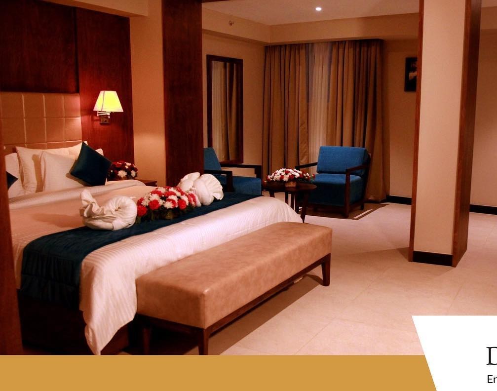 Deluxe Suite — king bed with teal accents and warm lighting